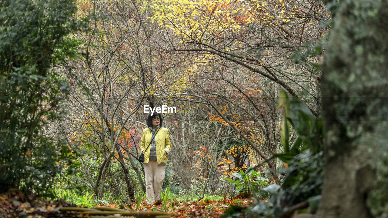 Woman standing in the trees of forest