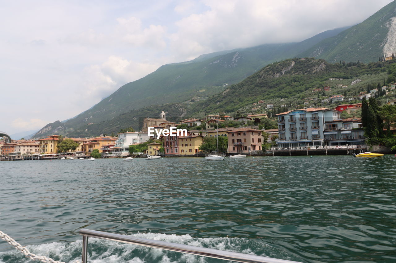 architecture, water, building exterior, mountain, built structure, building, city, sky, nature, sea, travel destinations, land, cloud, house, residential district, travel, landscape, environment, vacation, tourism, transportation, no people, coast, scenics - nature, town, beach, vehicle, beauty in nature, village, bay, outdoors, day, mountain range, cityscape, trip, waterfront, holiday, coastline, nautical vessel, community, mode of transportation, body of water, harbor, tranquility, idyllic