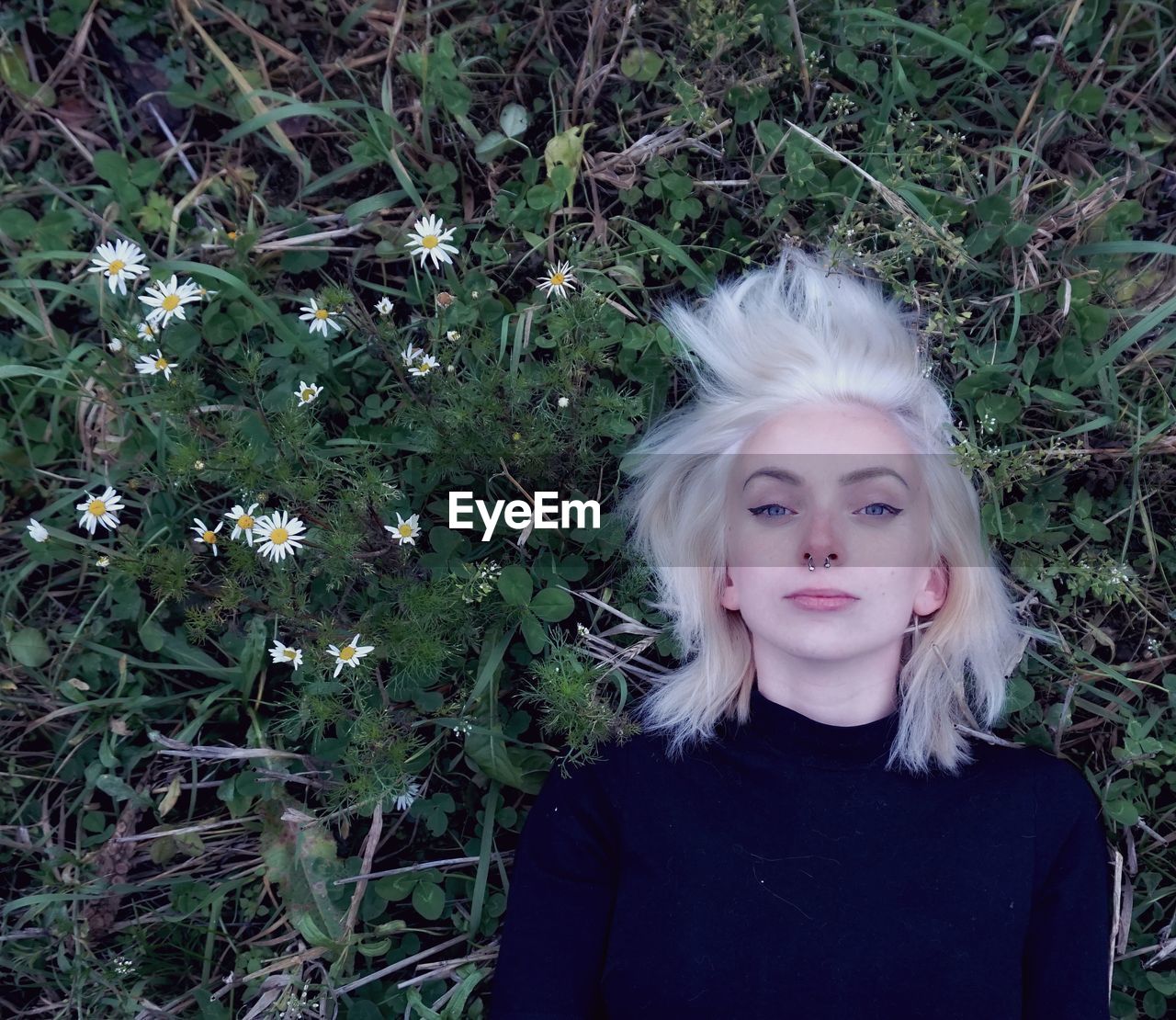 Overhead portrait of woman lying on grassy field