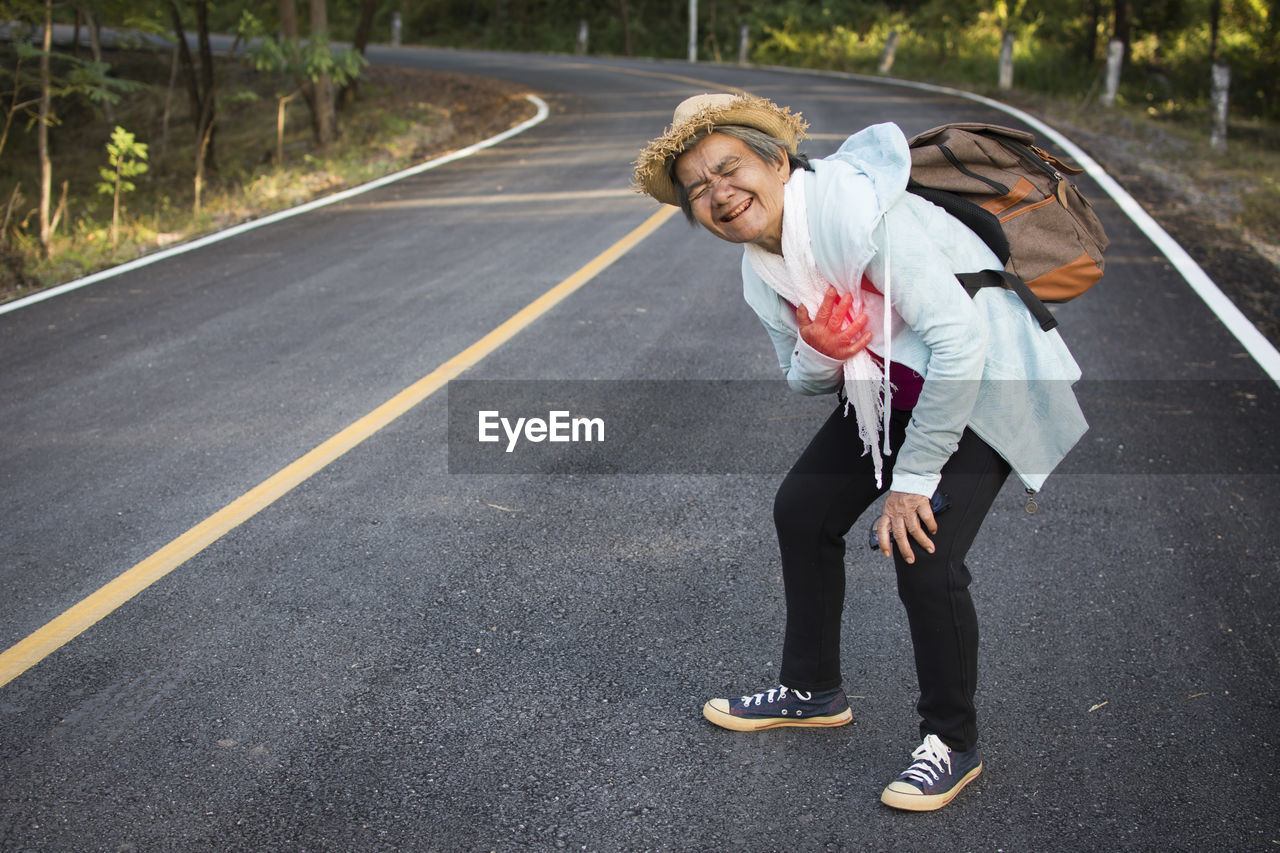 Side view of senior woman standing on road