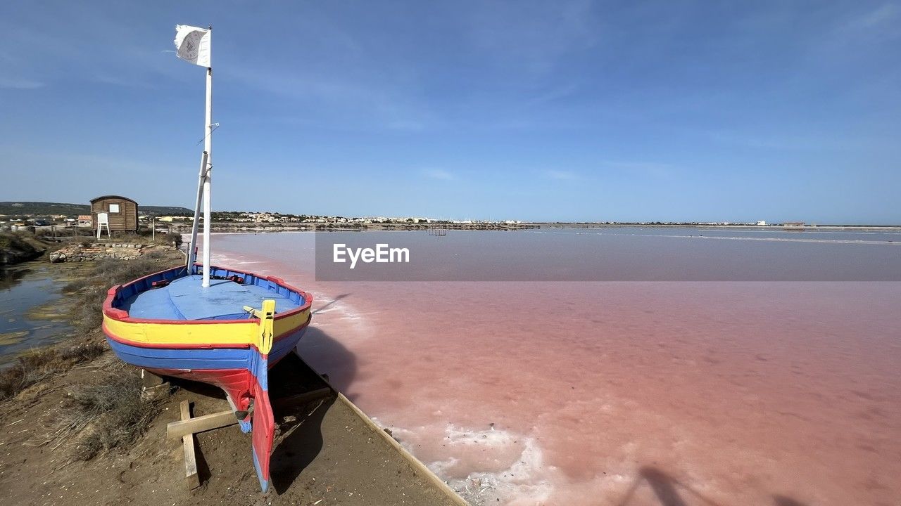 water, beach, sea, sky, land, nature, shore, sand, coast, tranquility, scenics - nature, ocean, nautical vessel, beauty in nature, vehicle, blue, no people, transportation, tranquil scene, day, outdoors, landscape, boat, environment, travel destinations, bay, cloud, travel, vacation, sunlight, mode of transportation, absence, moored, reflection, coastline, wave, idyllic, horizon, holiday, trip