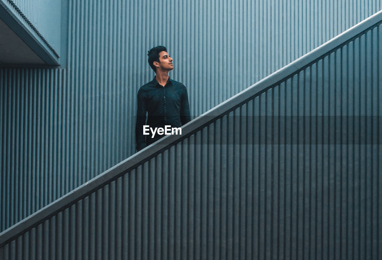 Young man standing on staircase