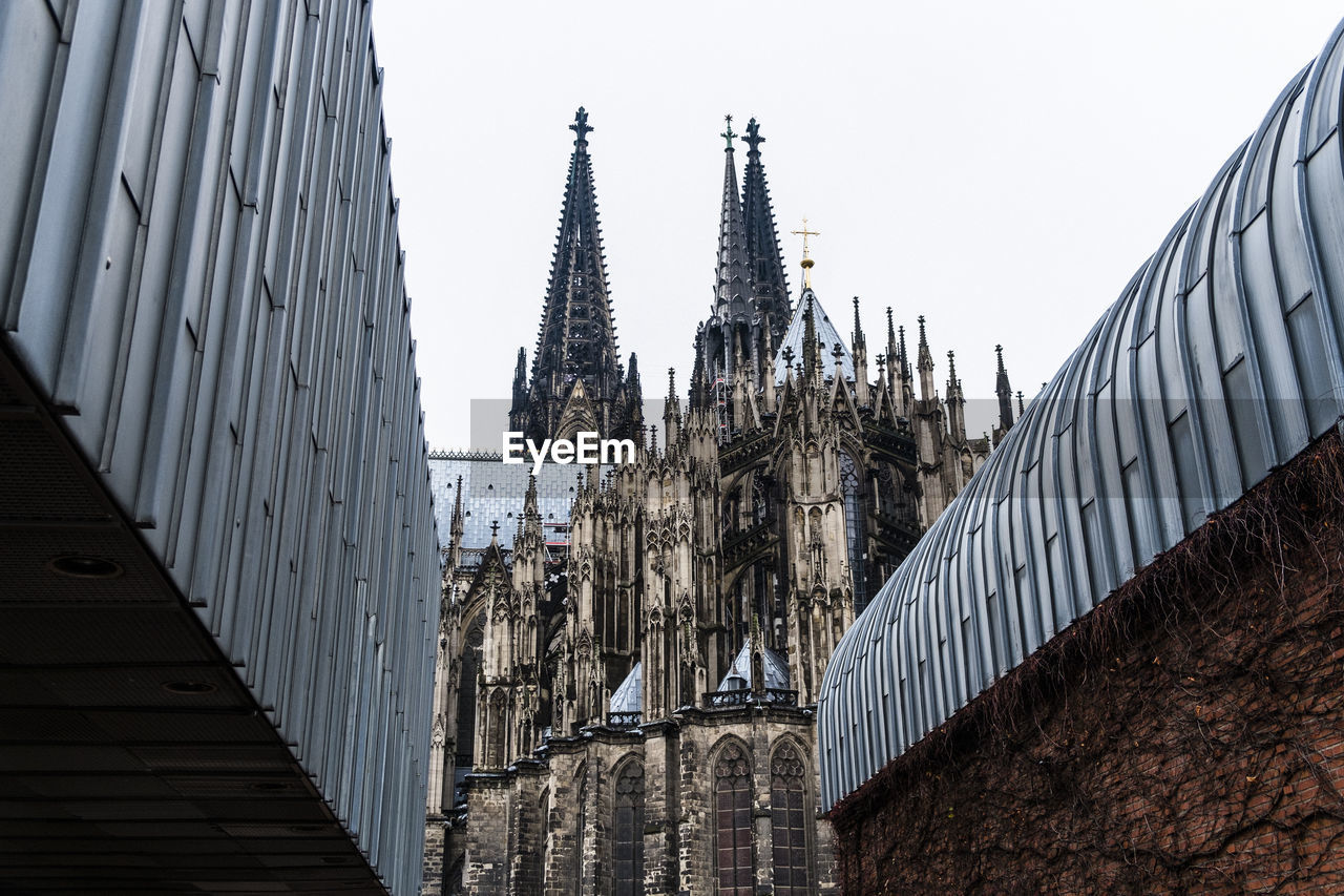 Low angle view of buildings and cologne cathedral against clear sky