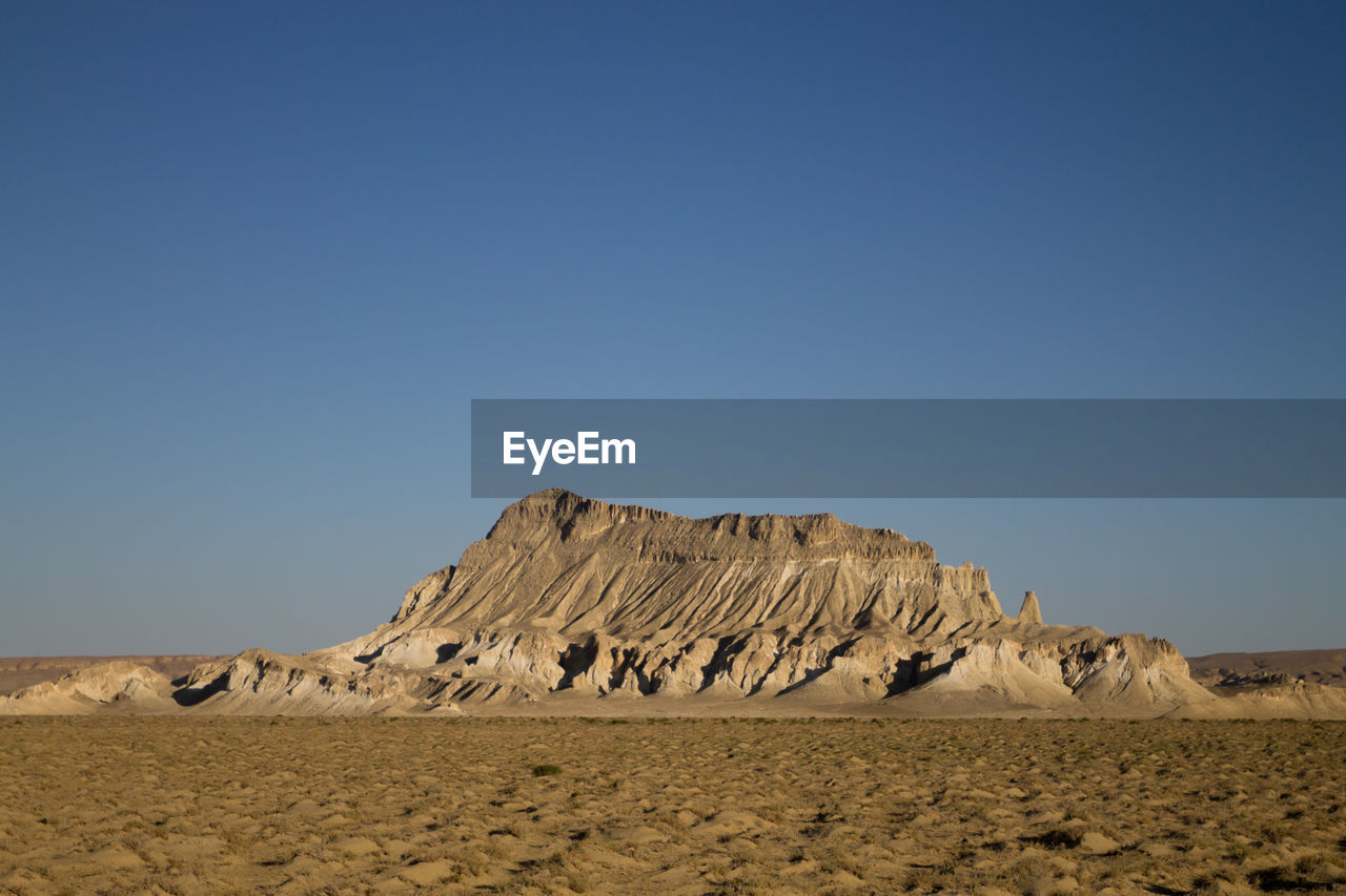 scenic view of rock formations against clear blue sky