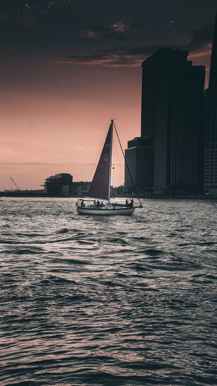 SAILBOAT SAILING ON SEA AGAINST SKY DURING SUNSET