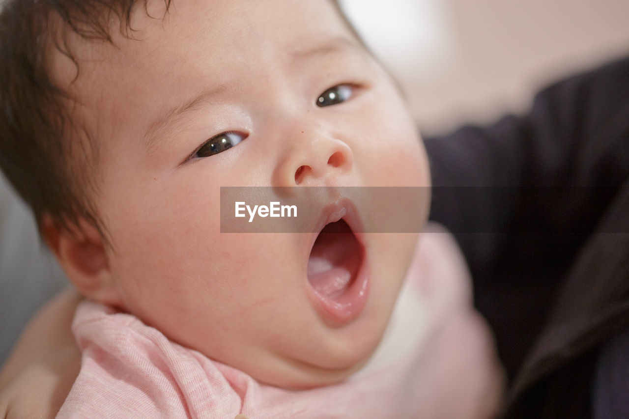 Close-up portrait of cute baby girl yawning