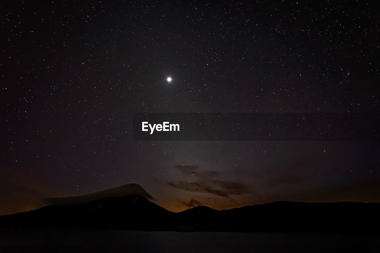 Scenic view of mountains against sky at night