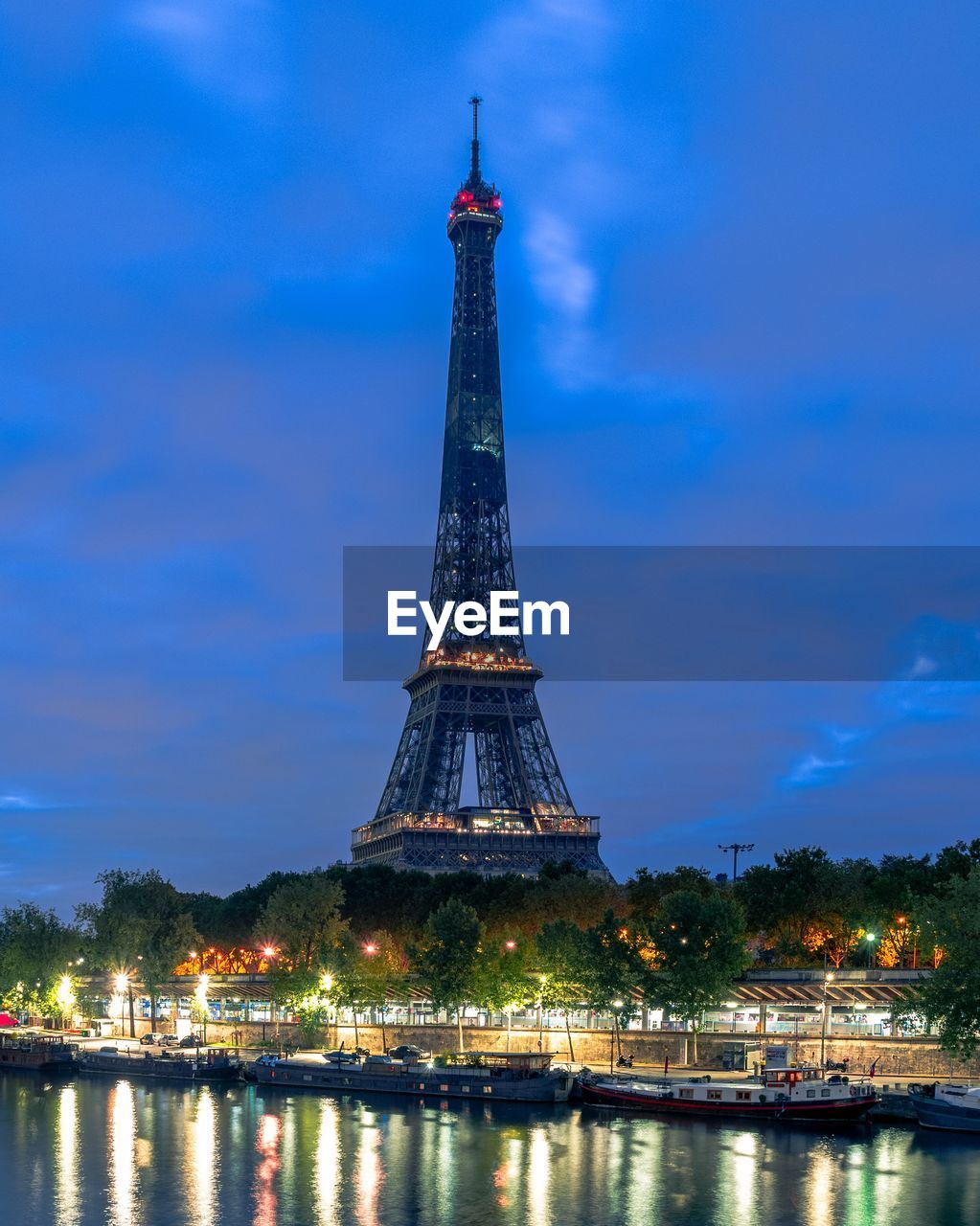 View of illuminated eiffel tower against cloudy sky