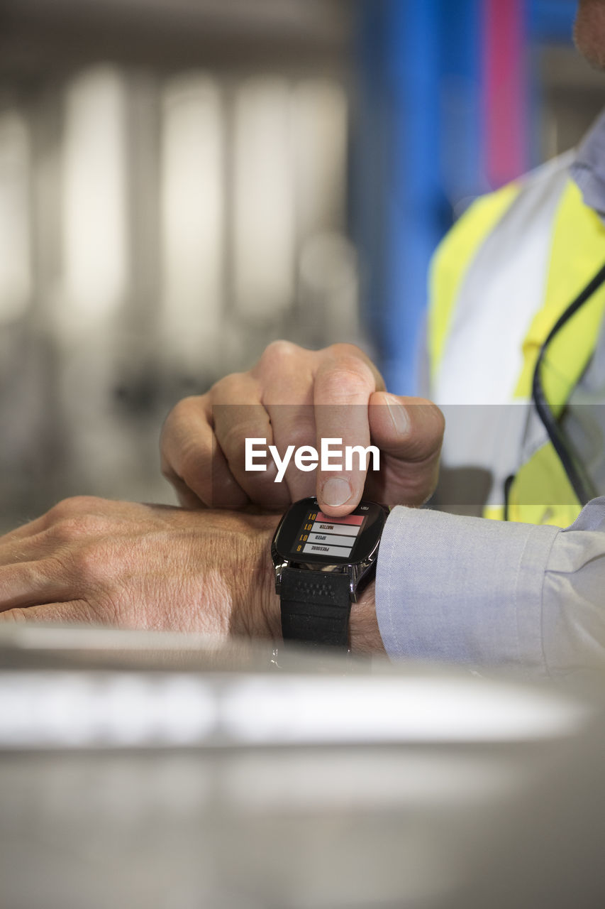 Man using smartwatch in industrial plant