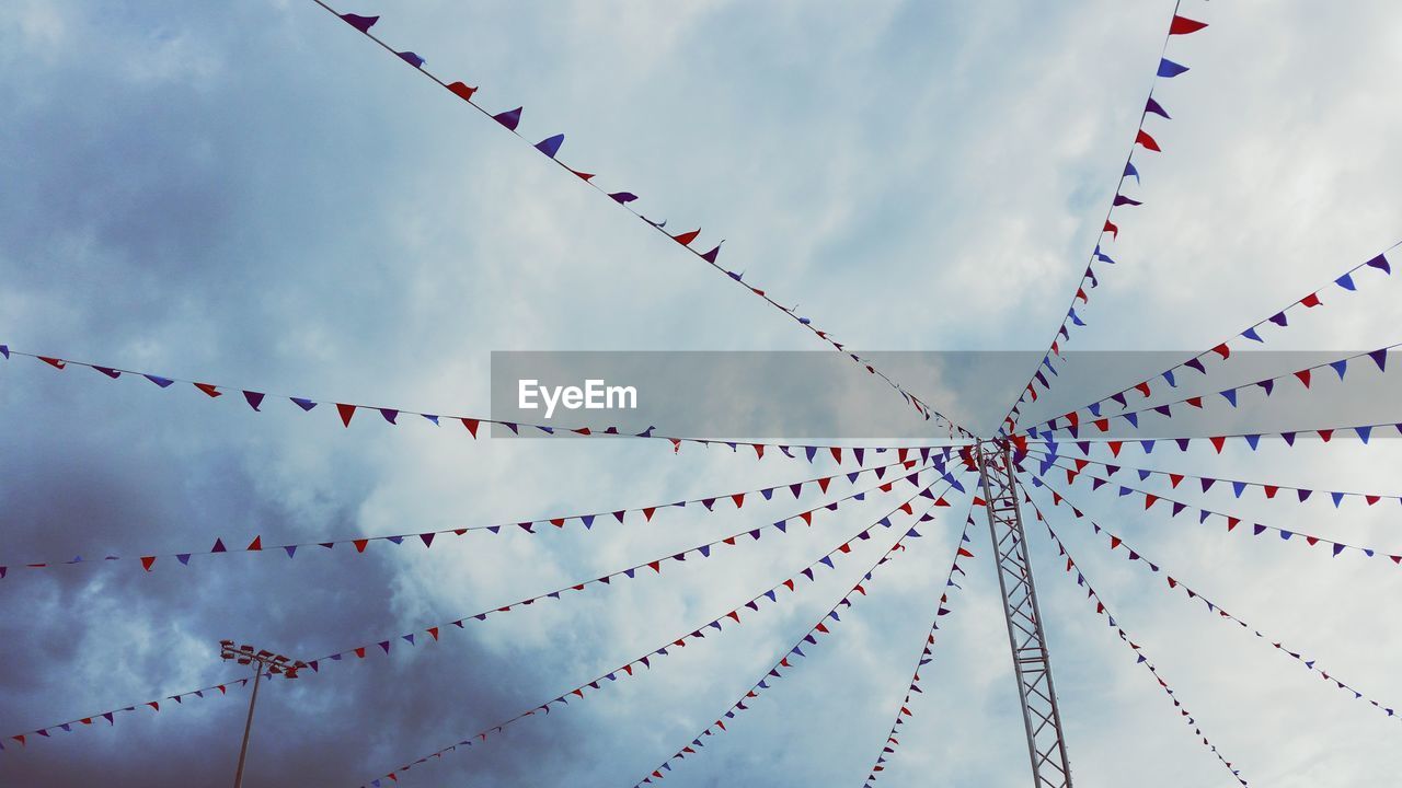 Low angle view of buntings hanging against sky