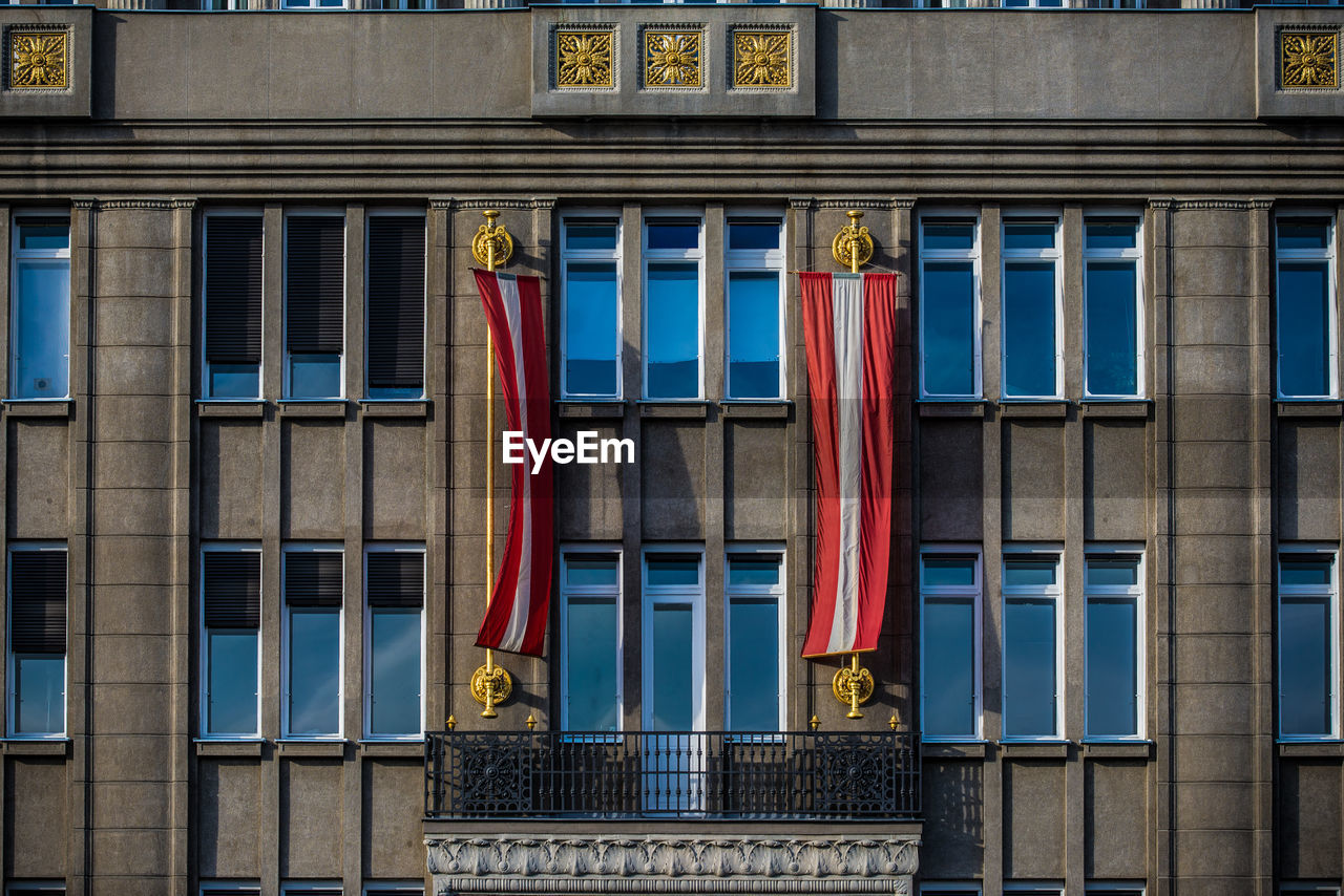 Low angle view of austrian flags hanging on building