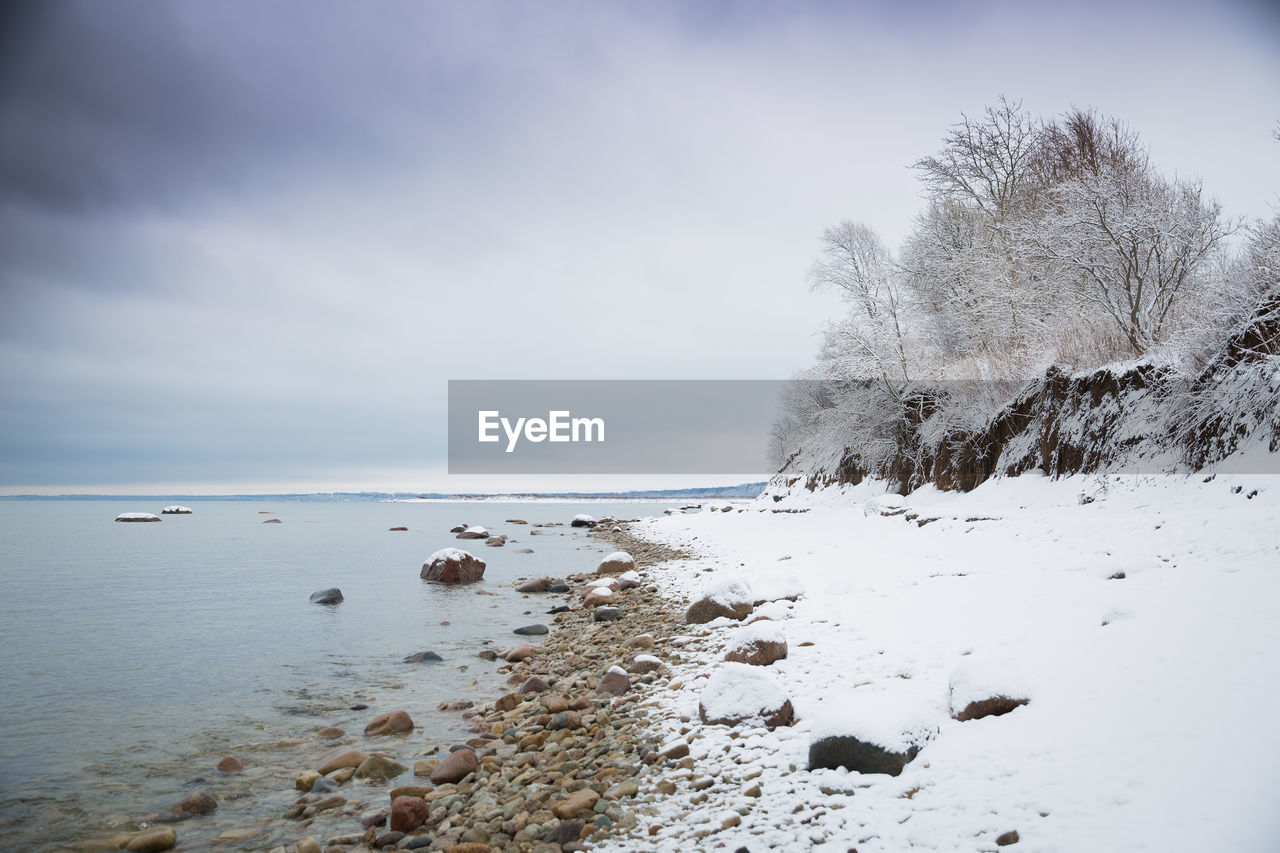 Scenic view of beach against sky during winter