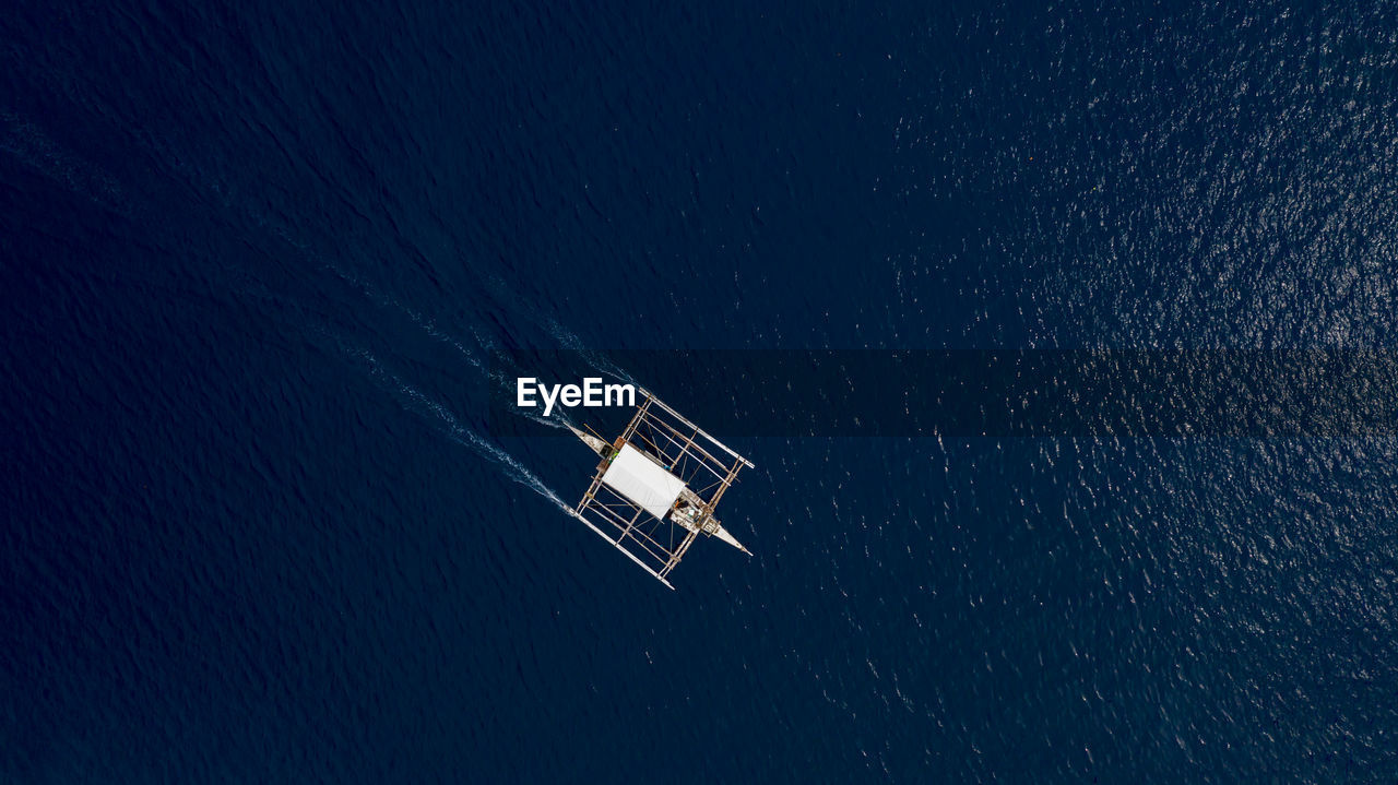 HIGH ANGLE VIEW OF SAILBOATS ON SEA