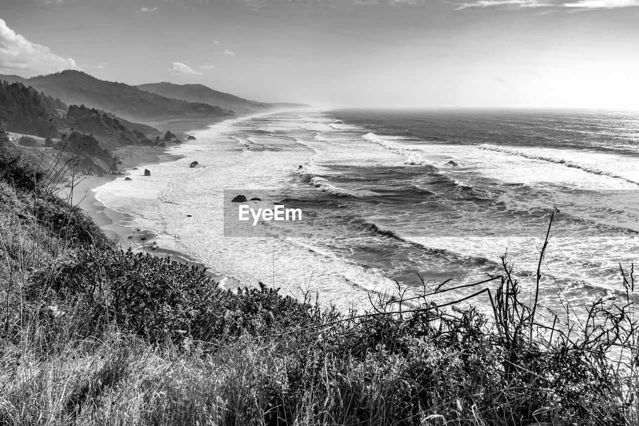 land, environment, scenics - nature, landscape, sky, black and white, water, nature, sea, beauty in nature, monochrome photography, beach, monochrome, coast, plant, cloud, tranquility, mountain, no people, grass, outdoors, tranquil scene, travel, day, wave, travel destinations, non-urban scene, tourism, sunlight, horizon, rock, coastline