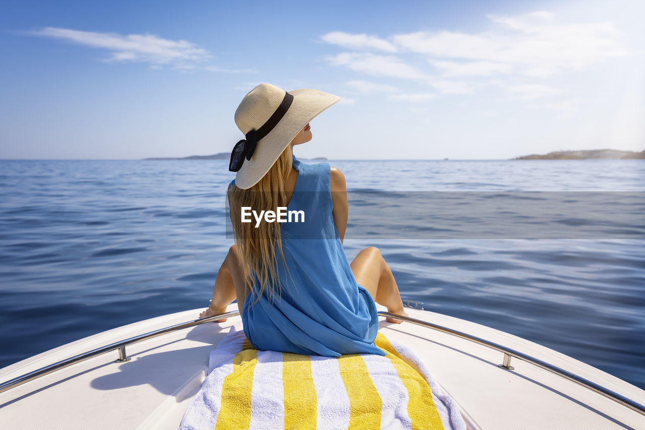 Rear view of woman in boat in sea against sky