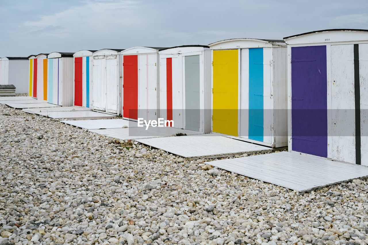 ROW OF BEACH HUT AGAINST SKY