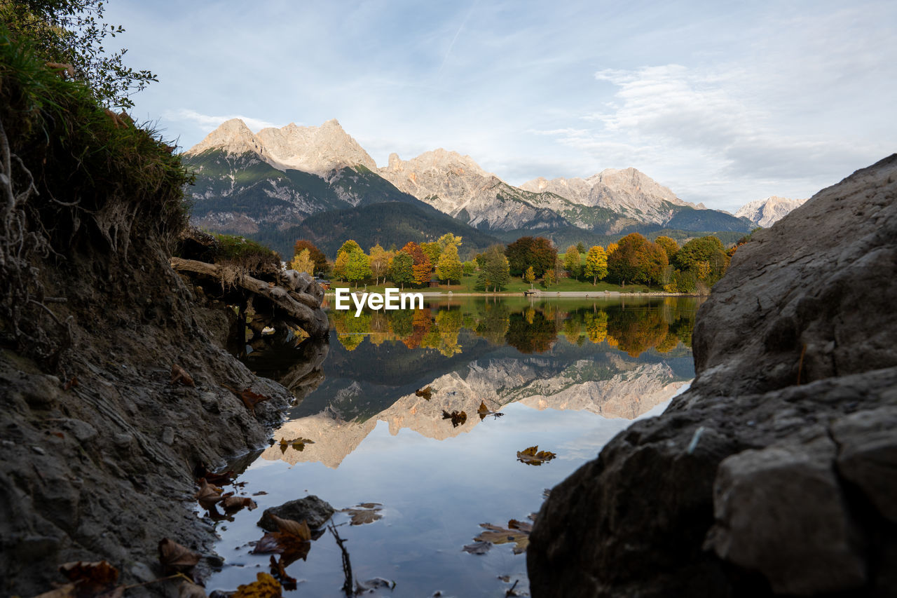 scenic view of lake by mountains against sky