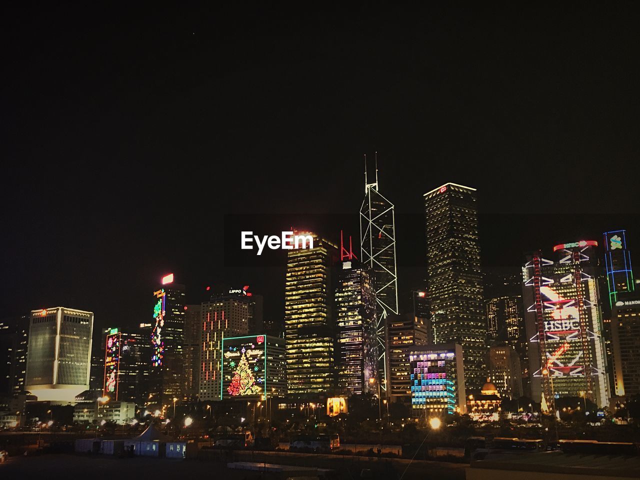 LOW ANGLE VIEW OF ILLUMINATED BUILDINGS AGAINST SKY AT NIGHT