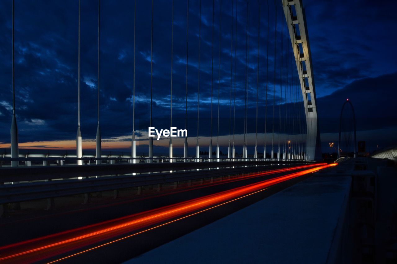 LIGHT TRAILS ON STREET AT NIGHT