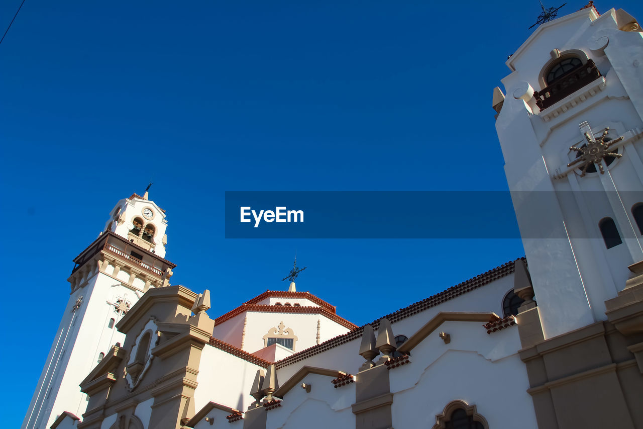 LOW ANGLE VIEW OF BUILDINGS AGAINST BLUE SKY