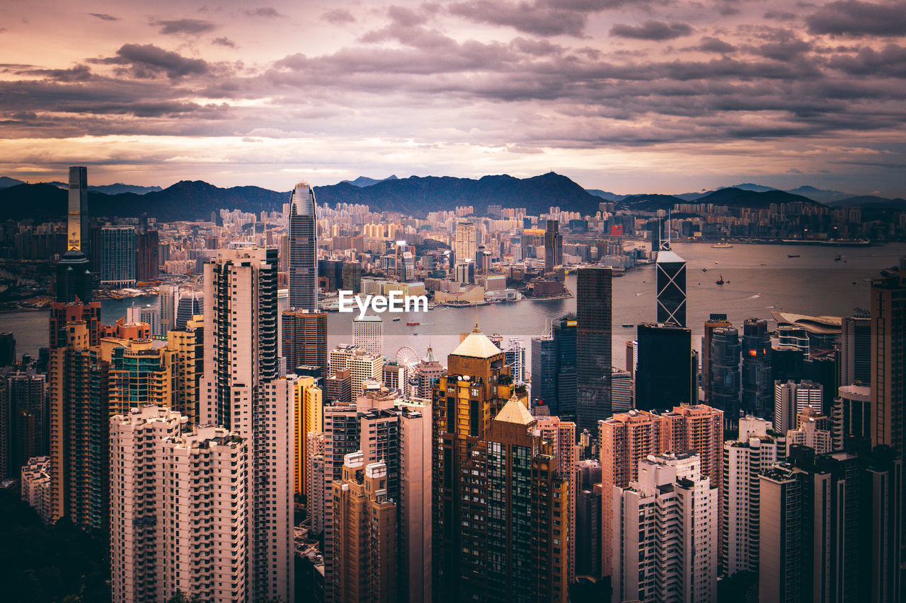 Aerial view of buildings in city against sky during sunset