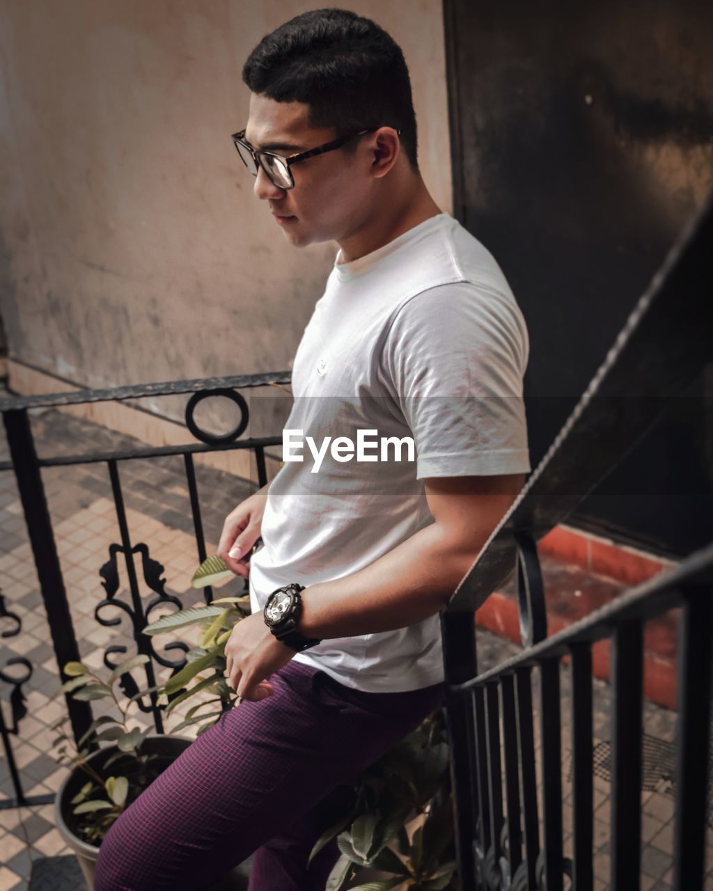 High angle view of young man looking away while standing on steps