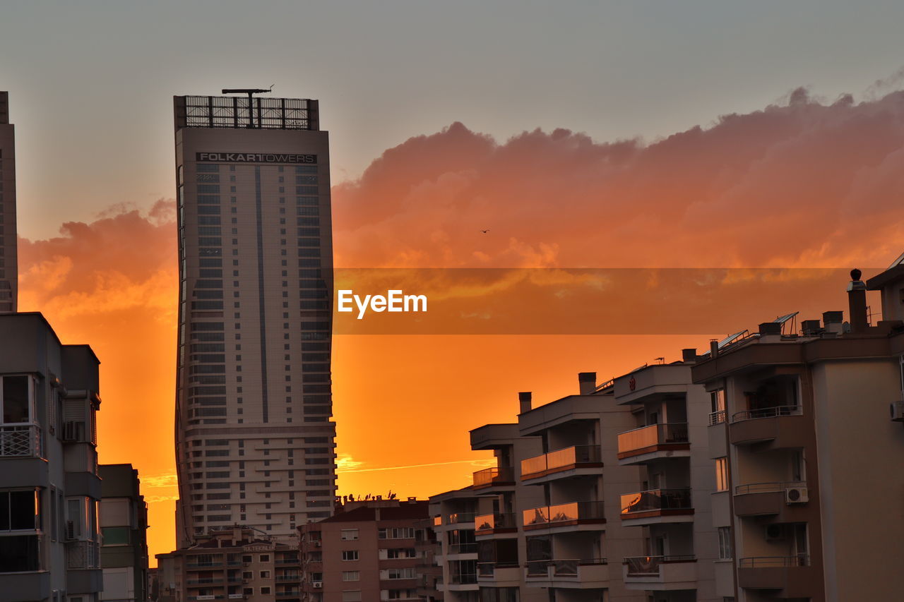 LOW ANGLE VIEW OF BUILDINGS AGAINST ROMANTIC SKY