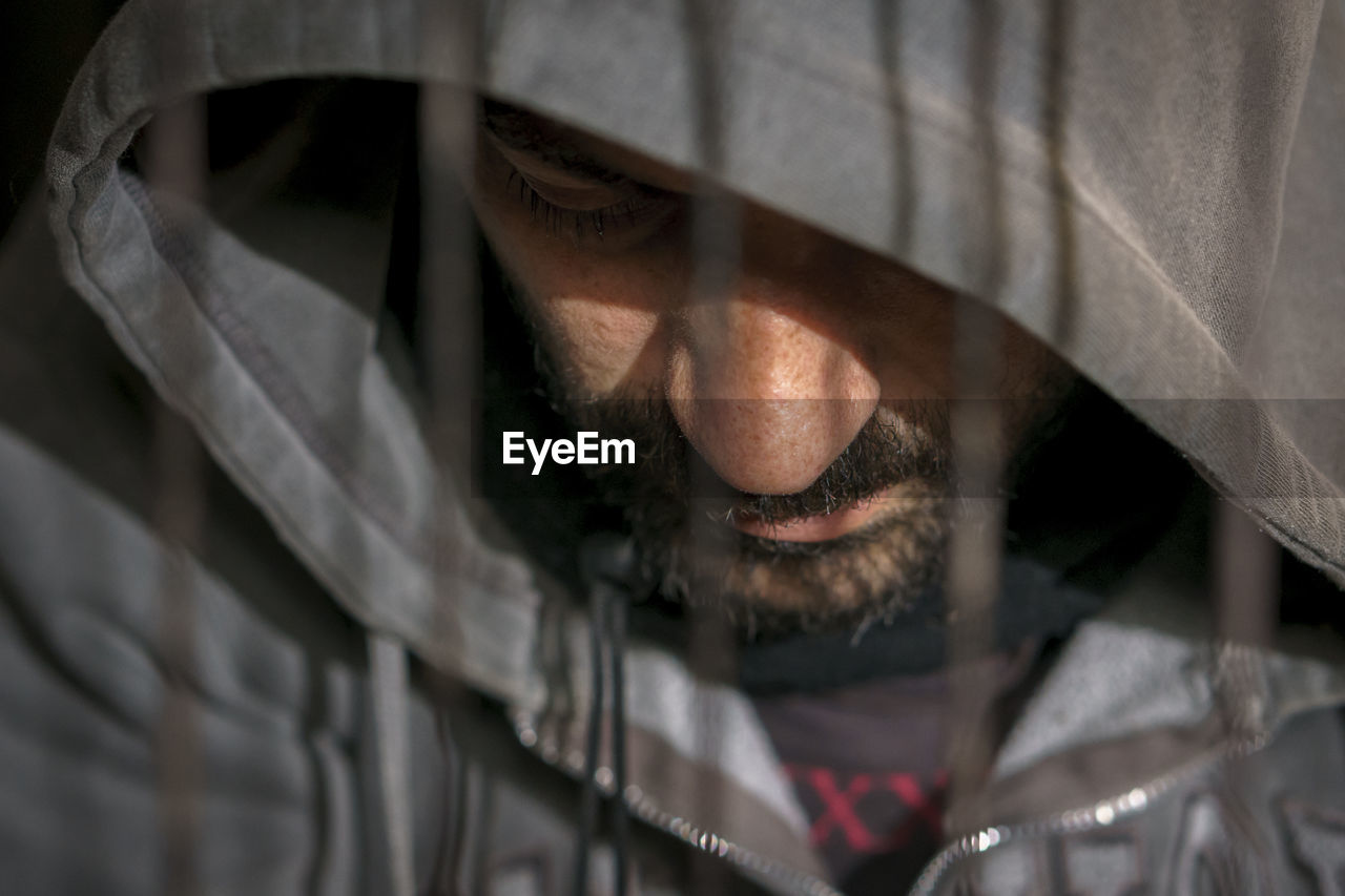 Close-up of depressed mature man wearing hooded shirt