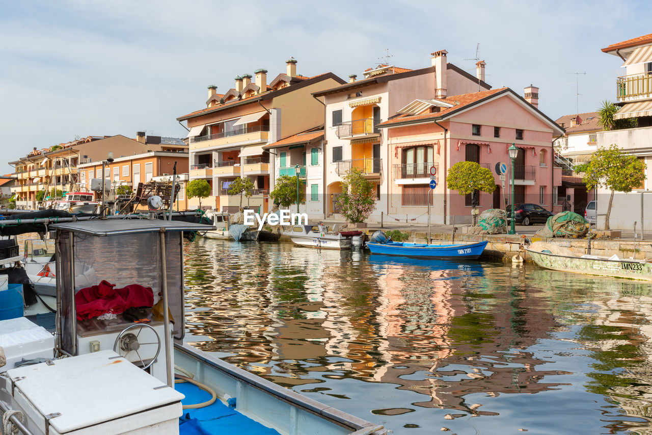 BOATS MOORED IN CANAL BY BUILDINGS IN CITY