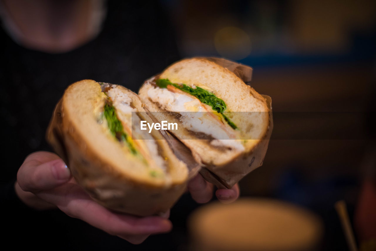 CLOSE-UP OF WOMAN HAND HOLDING BREAD