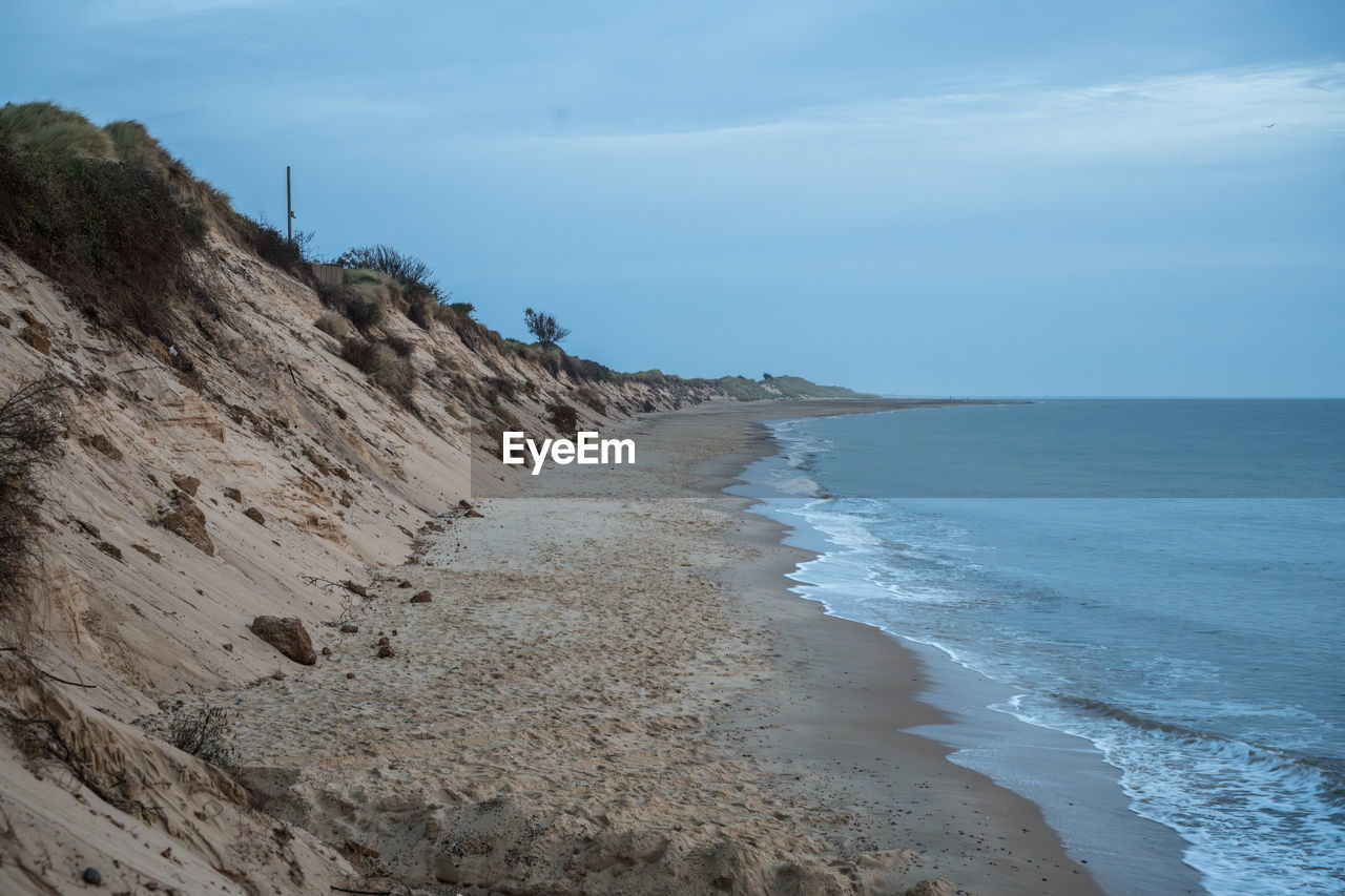 sea, land, water, beach, sky, scenics - nature, beauty in nature, ocean, body of water, nature, cliff, coast, sand, wave, shore, tranquility, cloud, horizon over water, tranquil scene, horizon, coastline, terrain, rock, environment, travel destinations, no people, motion, non-urban scene, day, idyllic, outdoors, landscape, travel, wind wave, vacation, blue, tourism, sports, bay, holiday, water sports, trip