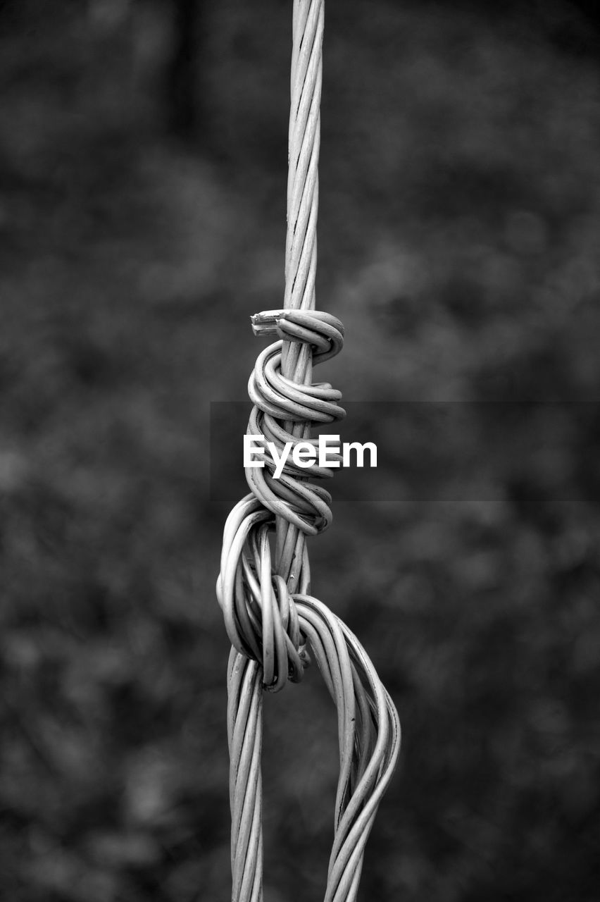 CLOSE-UP OF ROPE TIED UP ON METAL