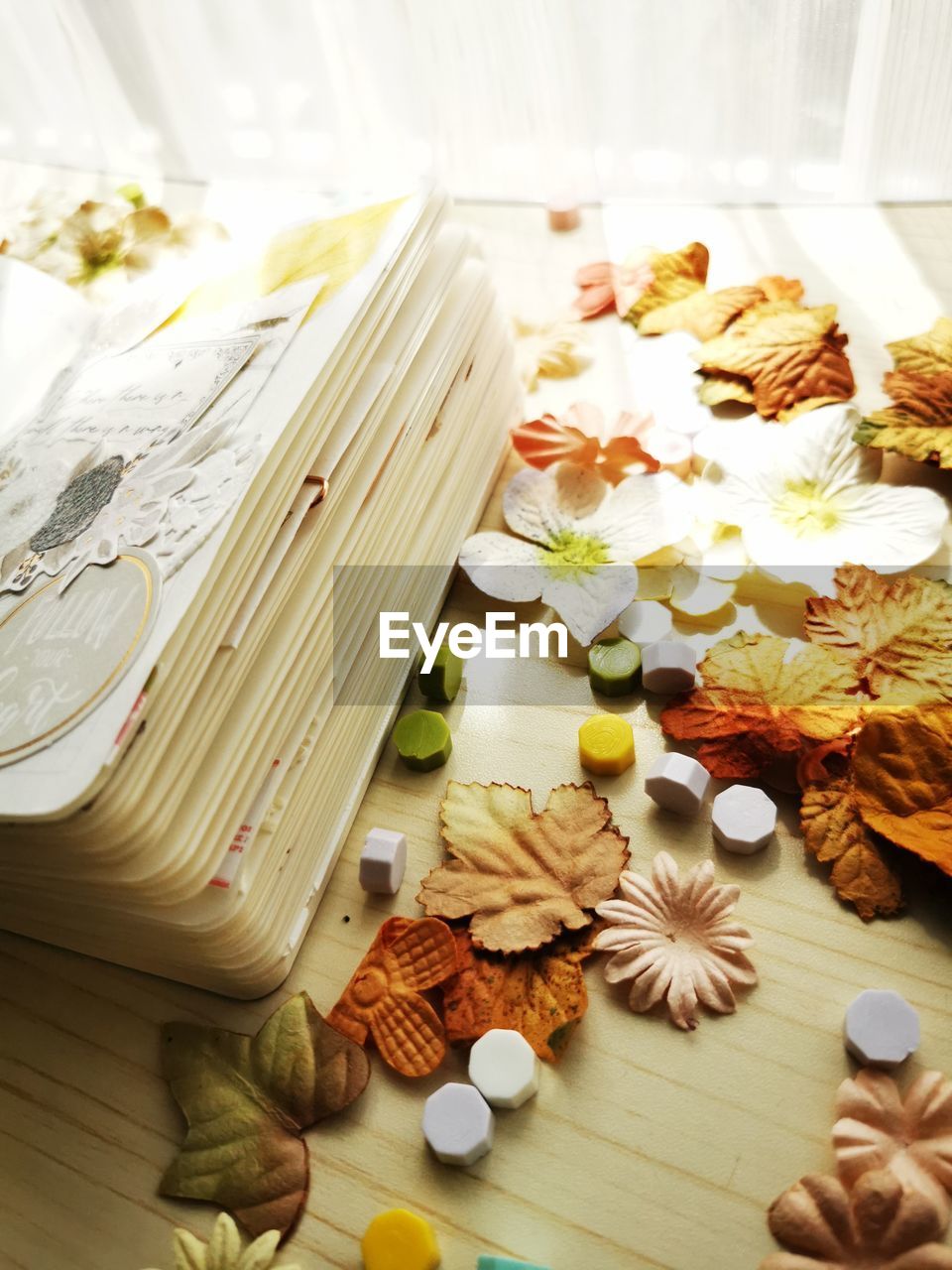 Portrait of a messy table filled with tiny flowers and leafs for scrapbook material