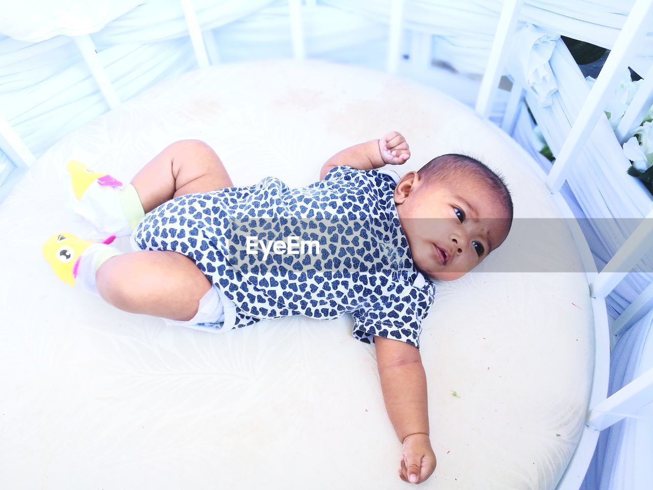 Cute baby girl lying in crib