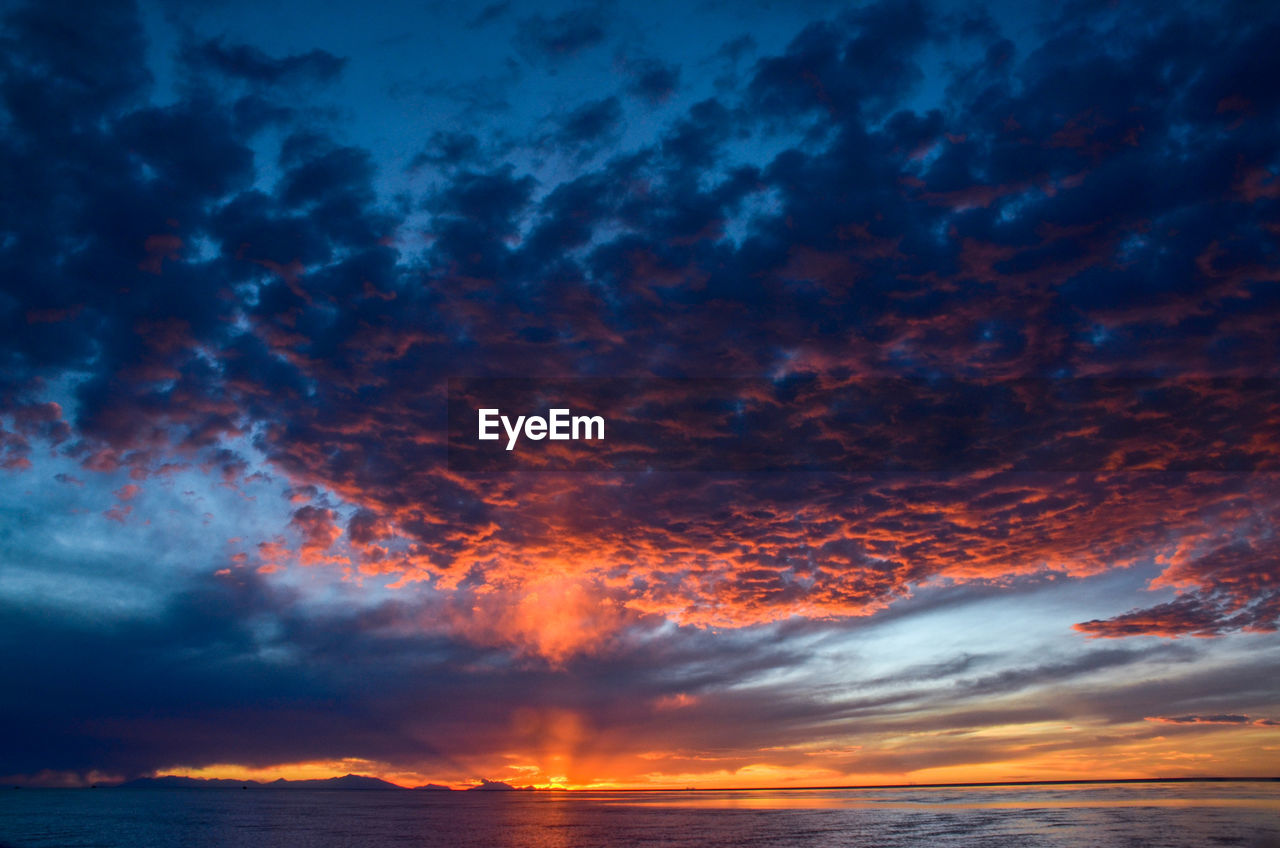 Scenic view of dramatic sky over sea during sunset