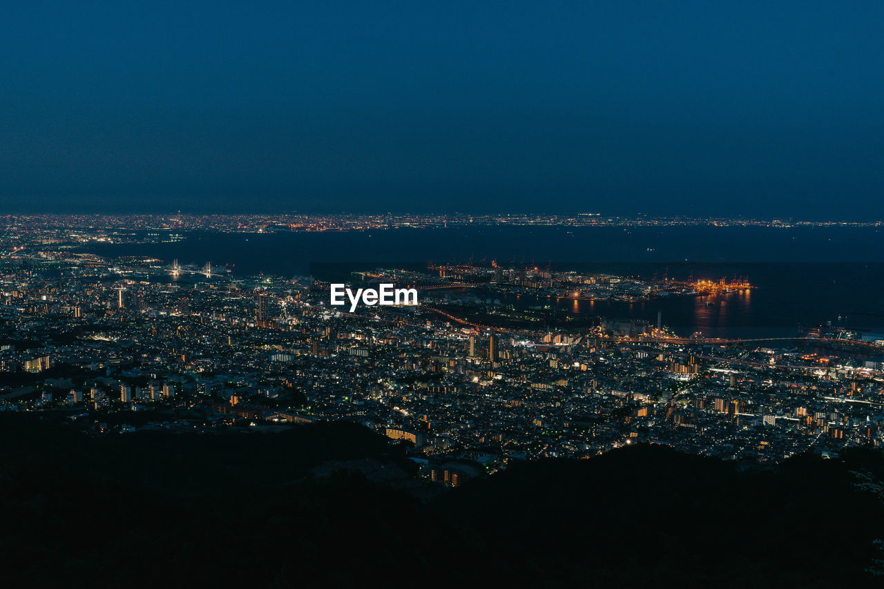 High angle view of illuminated city against sky at night