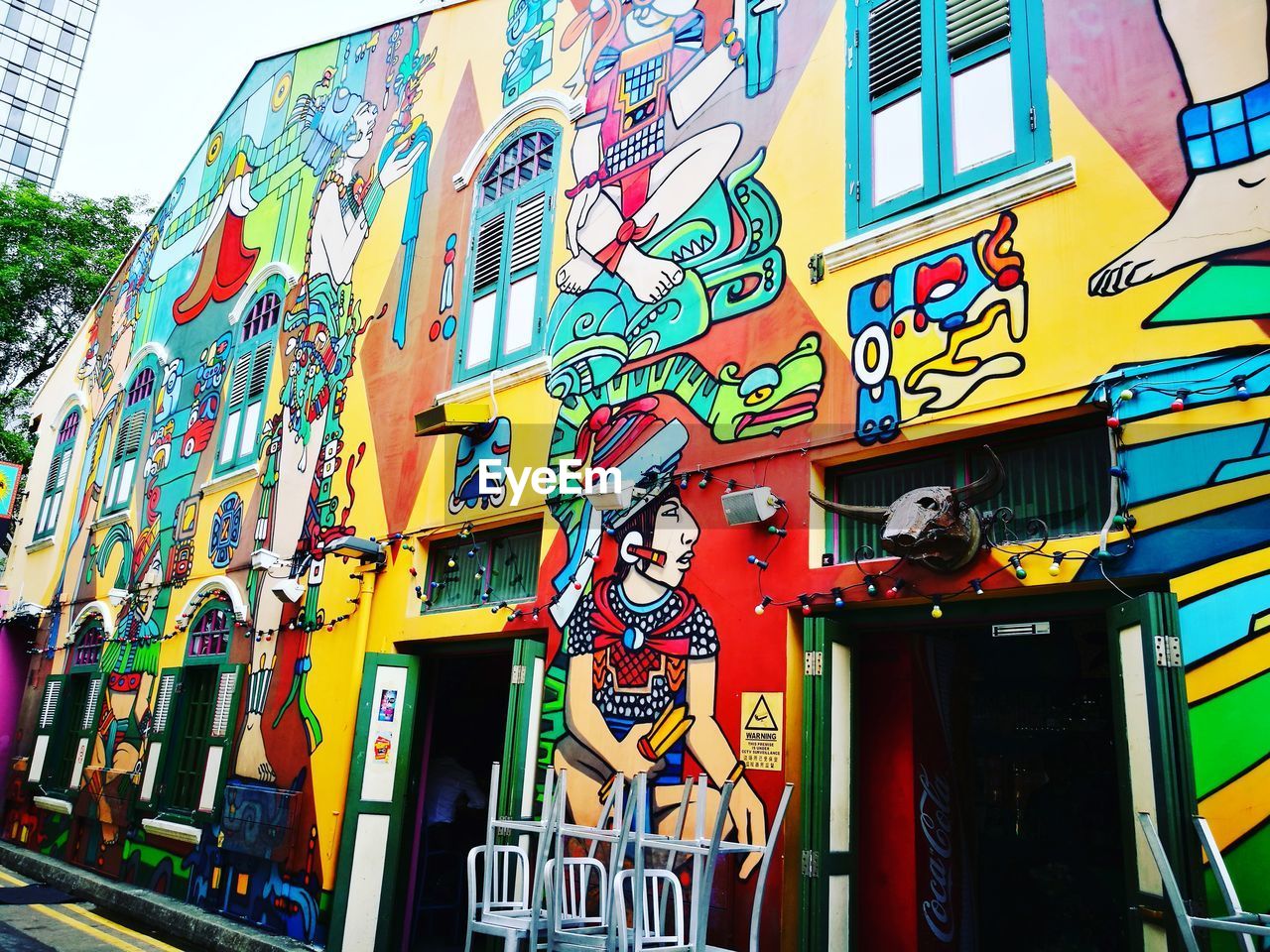 PERSON STANDING ON MULTI COLORED GRAFFITI WALL