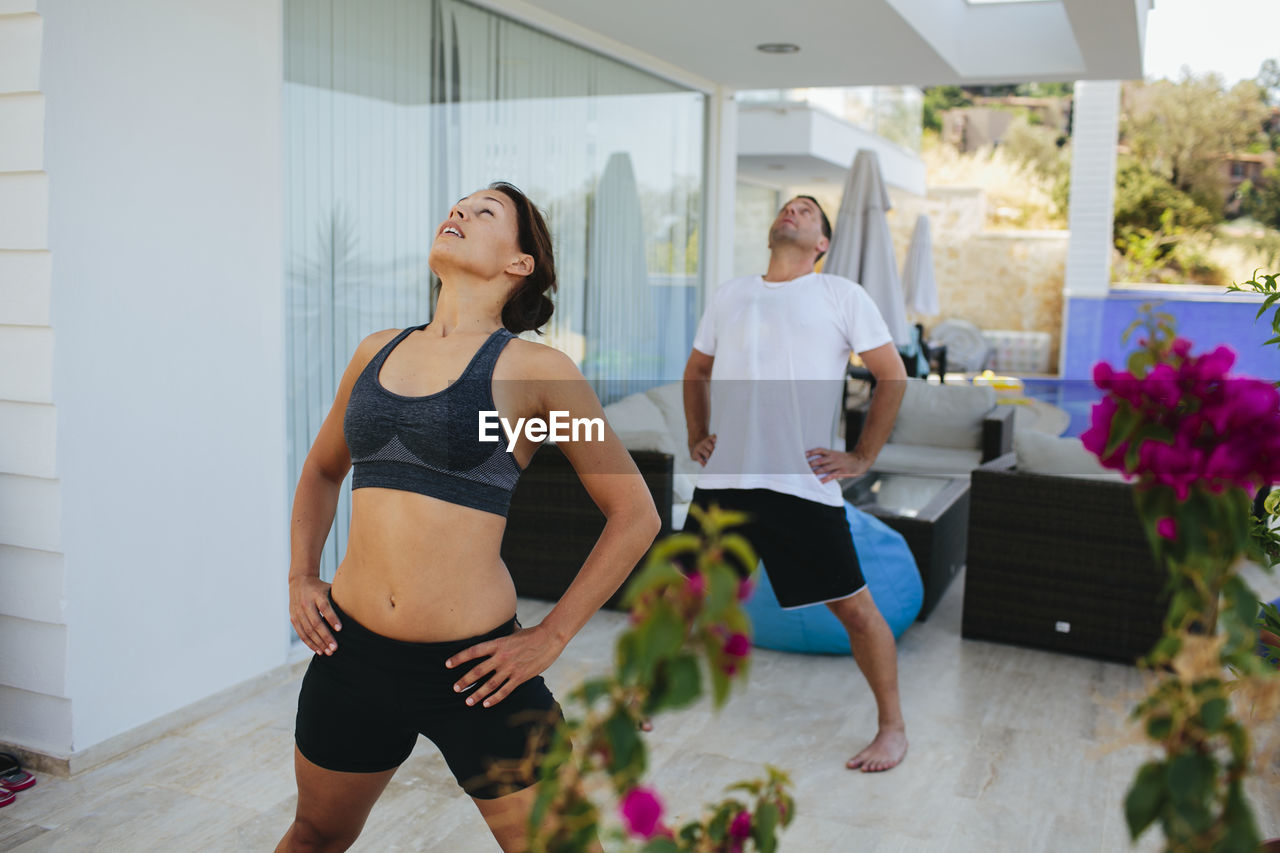 Young couple exercising on veranda