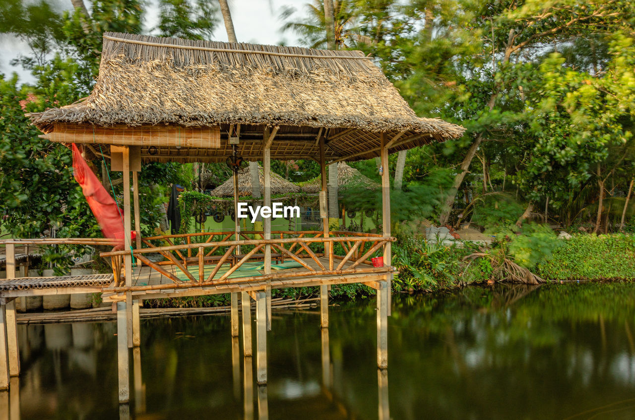 BUILT STRUCTURE WITH REFLECTION OF PLANTS IN LAKE