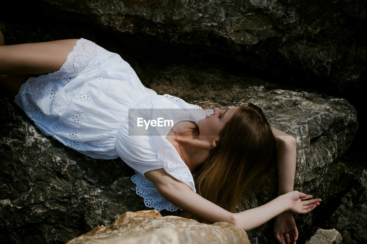 Young woman resting on rocks
