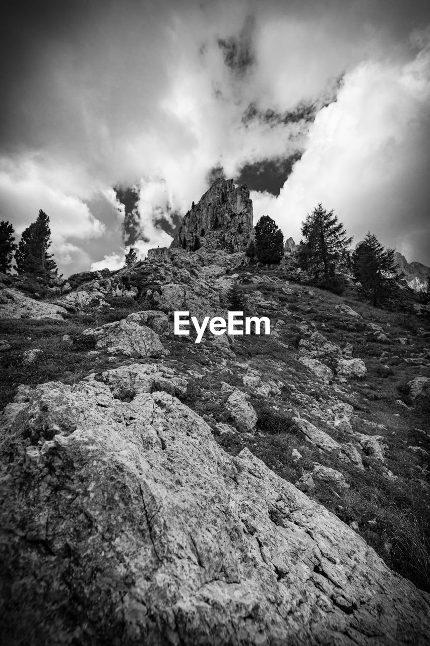 cloud, sky, rock, nature, mountain, darkness, environment, black and white, monochrome, landscape, monochrome photography, scenics - nature, tree, land, beauty in nature, snow, pinaceae, plant, extreme terrain, coniferous tree, no people, forest, travel, non-urban scene, outdoors, travel destinations, pine tree, mountain peak, tranquility, mountain range, dramatic sky, activity, pine woodland