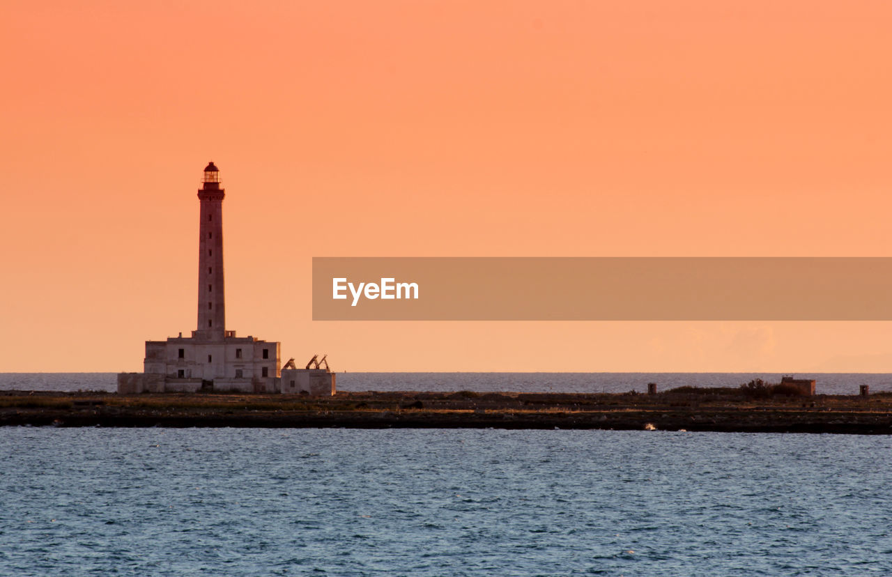 Lighthouse at seaside during sunset