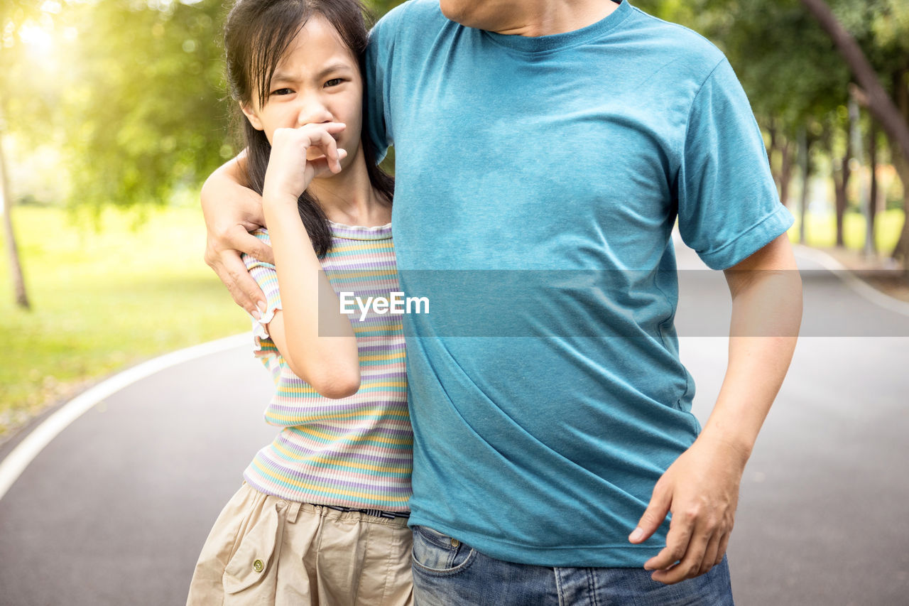MOTHER AND DAUGHTER STANDING ON SIDEWALK