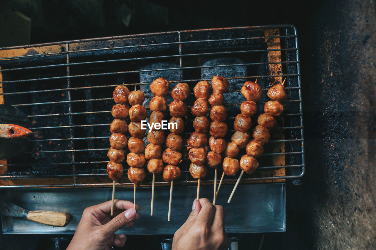 MIDSECTION OF PERSON PREPARING FOOD ON BARBECUE