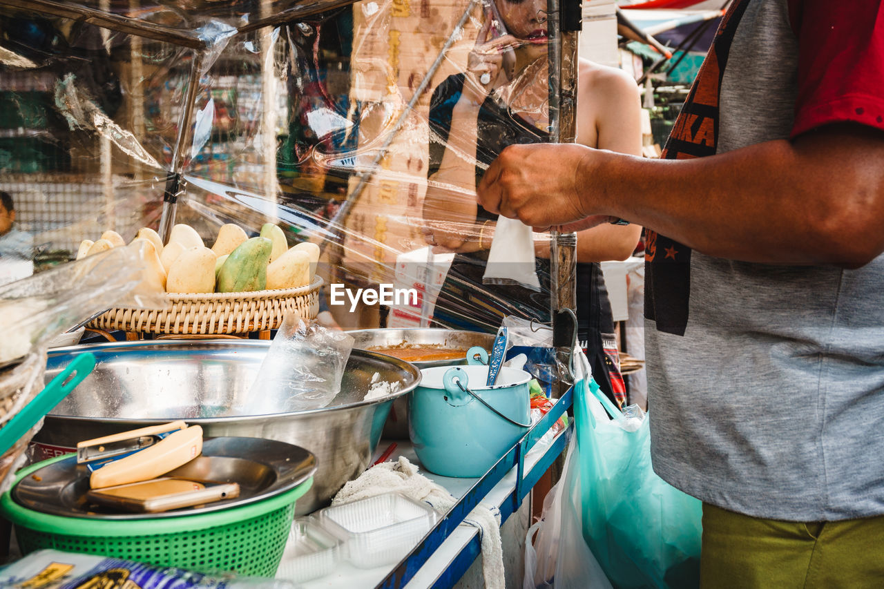 Midsection of man selling fruit at market