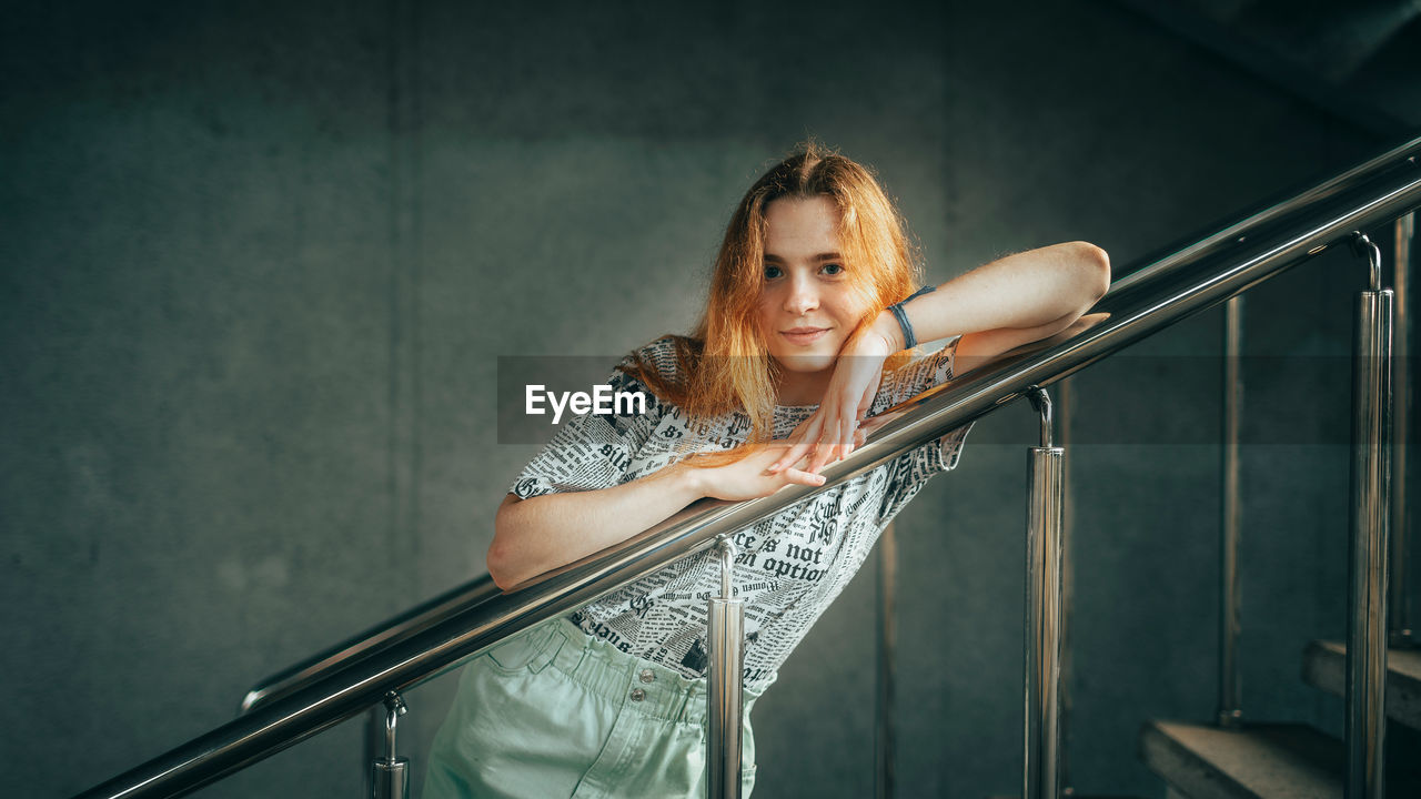Portrait of young woman sitting on staircase