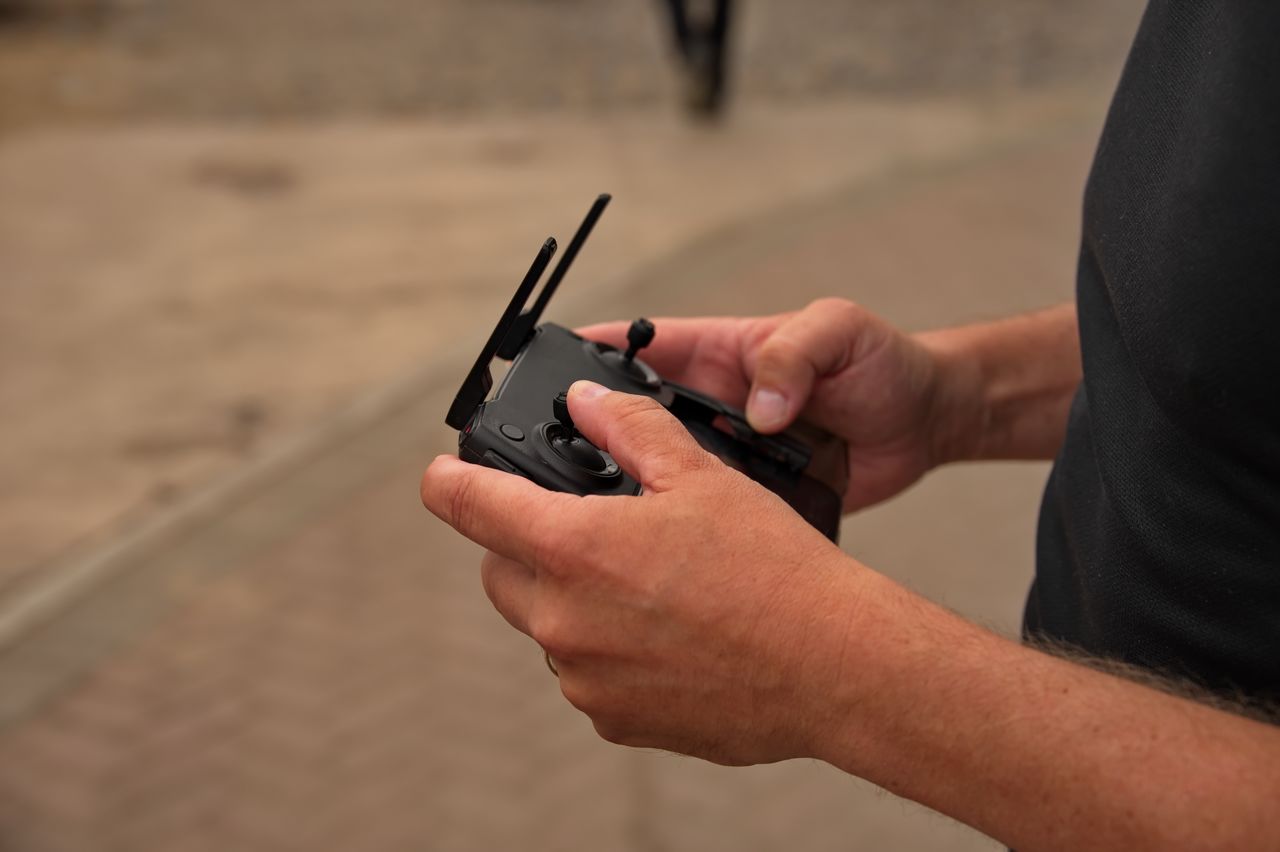 Closeup of mans hands holding the remote control of drone