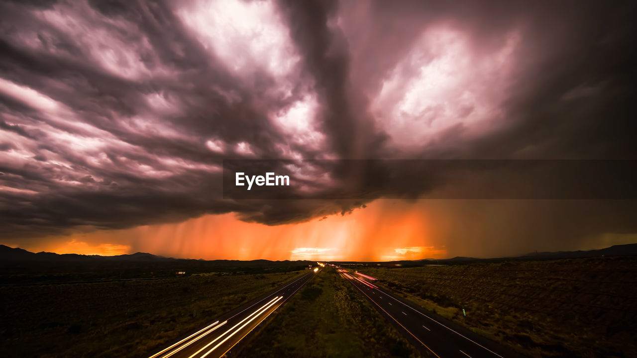 High angle view of light trails on road against sky during sunset