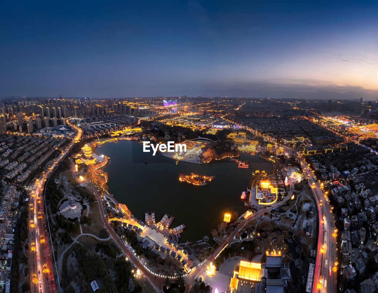 High angle view of illuminated cityscape against sky at night