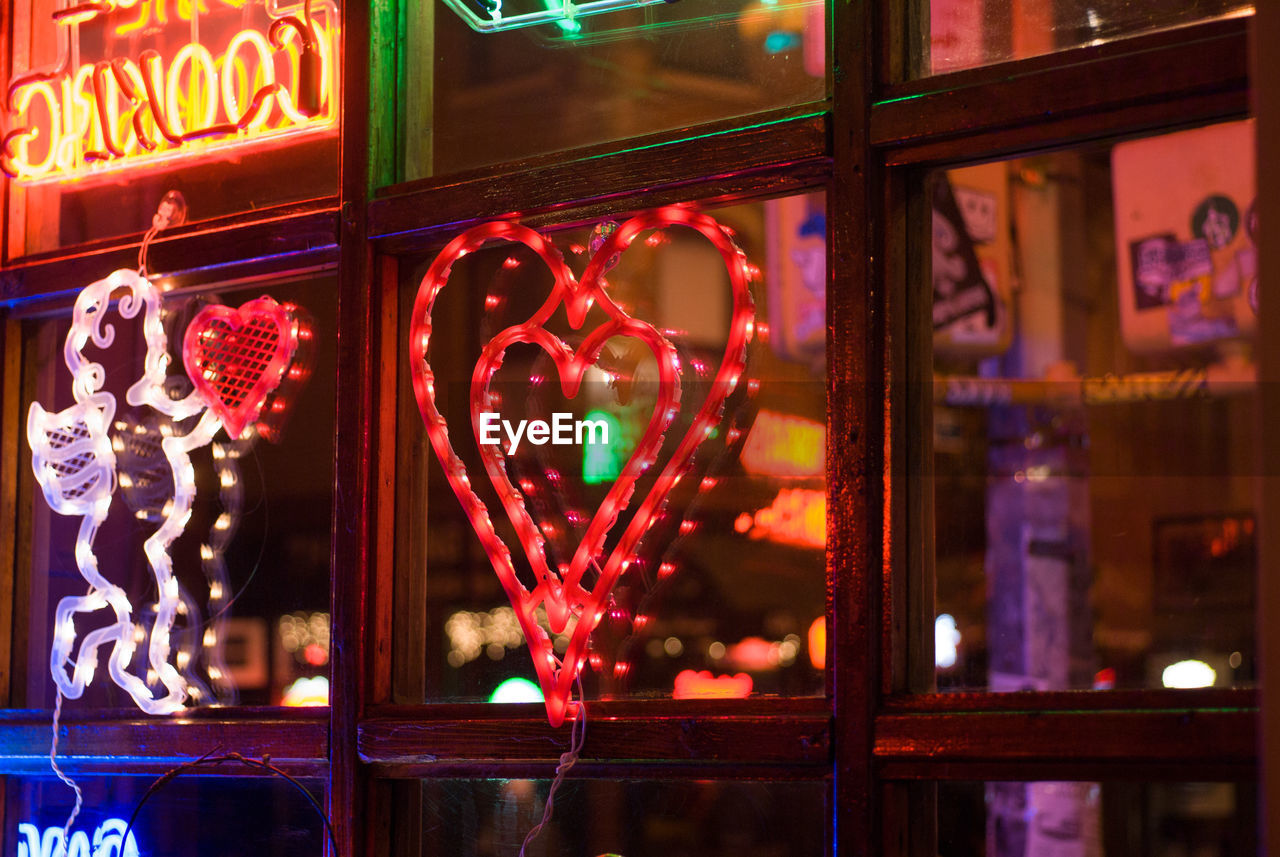 Close-up of heart shape on glass window at night